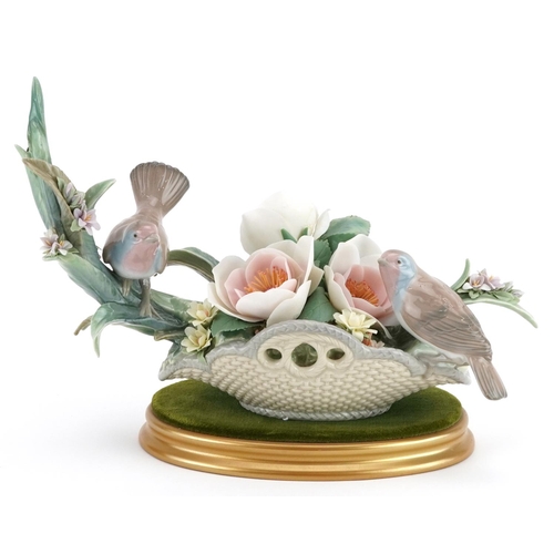 777 - A Lladro study of two birds sitting on flowers, decorated by E. Ordaz, - numbered N-762, 31cm in len... 