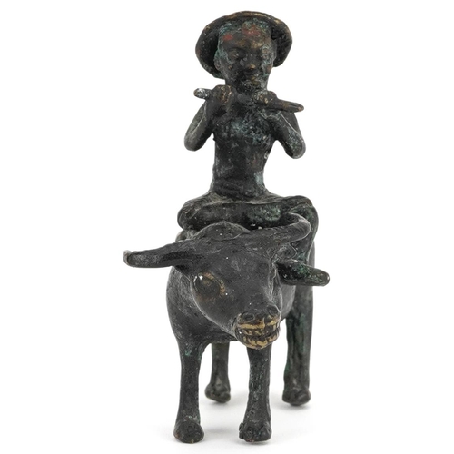 147 - A Chinese bronze figure group of man on the back of a water buffalo, 20th century, 10cm high.