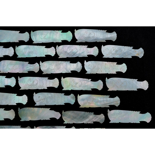 104 - A collection of Chinese carved mother of pearl gaming tokens including some in the form of fish, the... 