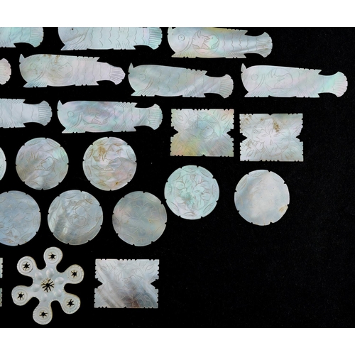 104 - A collection of Chinese carved mother of pearl gaming tokens including some in the form of fish, the... 