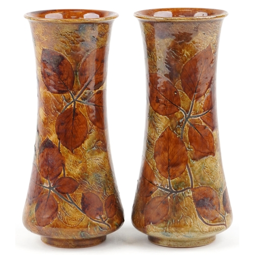 189 - A pair of Royal Doulton stoneware vases decorated with leaves, impressed marks to the base, 24cm hig... 