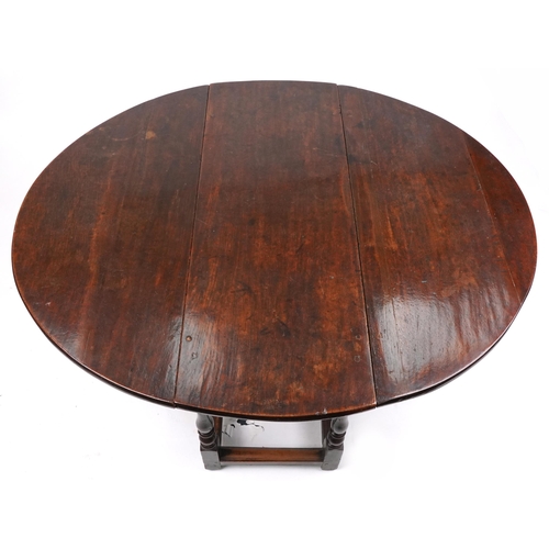 1022 - An 18th century oval gateleg table raised on turned and block supports, 70cm high x 120cm wide