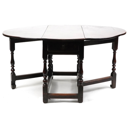 1022 - An 18th century oval gateleg table raised on turned and block supports, 70cm high x 120cm wide