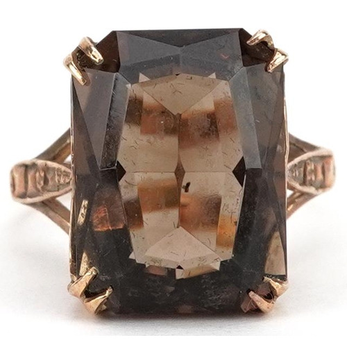 306 - A 9ct gold rectangular cut smoky quartz ring with pierced setting and engraved shoulders, size P, 4.... 