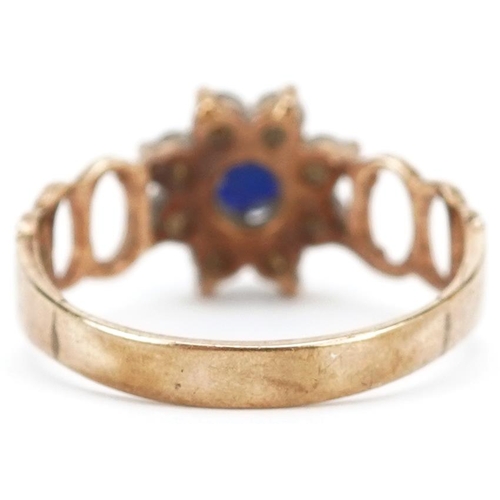 390 - A 9ct gold sapphire and clear stone flower head ring with pierced shoulders, size M/N, 2.2g.