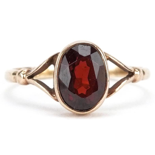 2372 - A 9ct gold garnet solitaire ring with split shoulders, size M, 1.6g.