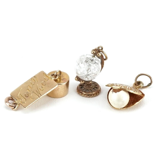 2499 - Three 9ct gold charms including a crystal globe, the largest 2.2cm in length, total weight 3.5g.