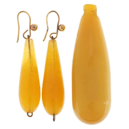 2522 - A butterscotch amber coloured bead pendant and a pair of similar drop earrings with yellow metal mou... 