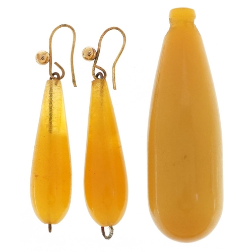 2522 - A butterscotch amber coloured bead pendant and a pair of similar drop earrings with yellow metal mou... 