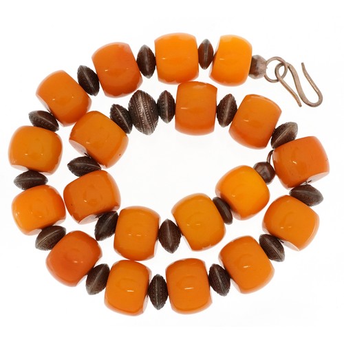 628 - An amber coloured bead necklace with white metal spacers and clasp, each bead approximately 21mm in ... 