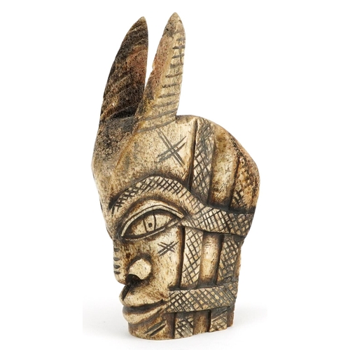 224 - An African carved bone horned figural bust, 20th century, 22cm high.