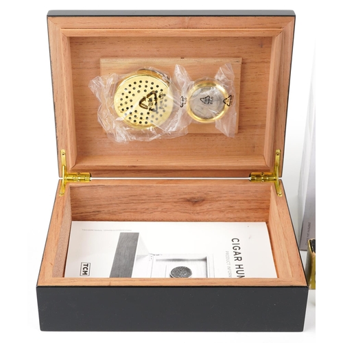 1179 - A TCM cigar humidor together with a similar cigar humidor, 29cm wide.