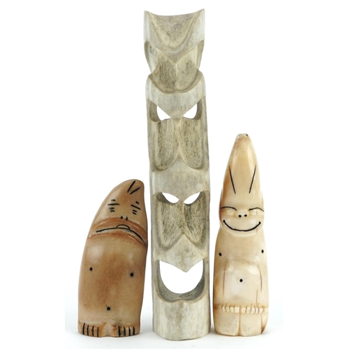 231 - Two mid 20th century carved bone Billikin charms together with a carved antler mask totem by Elisha ... 