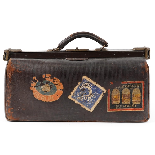 21 - A vintage brown leather doctor's bag, 50cm wide, with travel labels including Budapest, Berlin and N... 