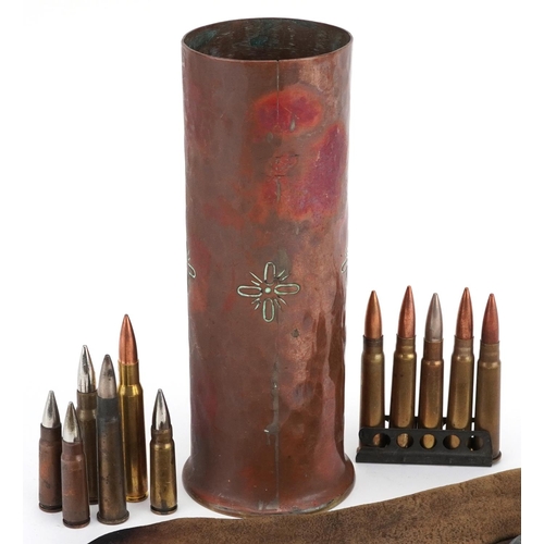 715 - A collection of militaria including trench art shell case, powder flask and ammunition shells.