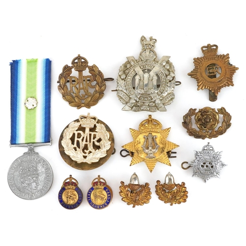 704 - A collection of British military interest cap badges, buttons and a South Atlantic style medal.