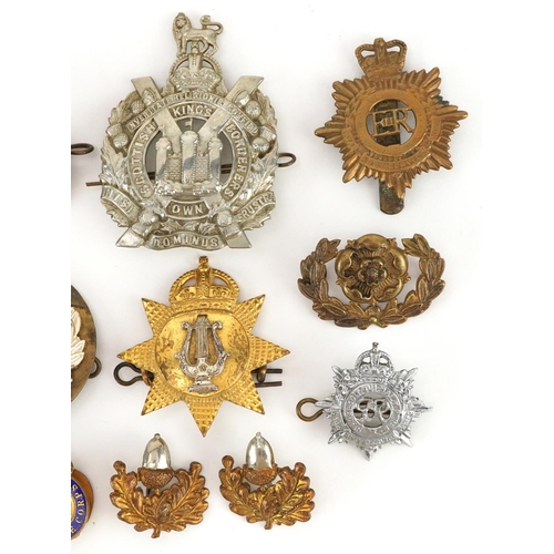 704 - A collection of British military interest cap badges, buttons and a South Atlantic style medal.