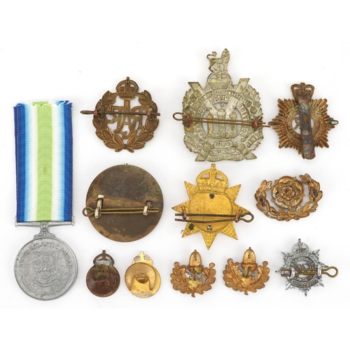 704 - A collection of British military interest cap badges, buttons and a South Atlantic style medal.