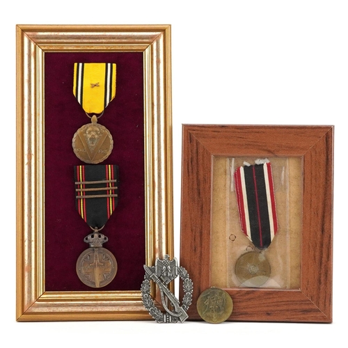 713 - Four German military interest medals and a cap badge.