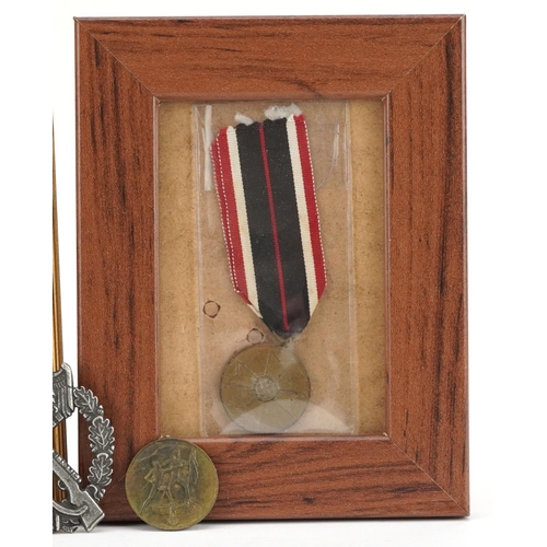 713 - Four German military interest medals and a cap badge.