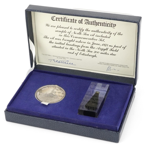 1326 - A sample of North Sea oil and a commemorative silver medallion housed in a presentation box, with ce... 