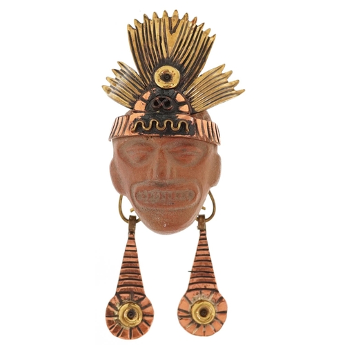 2365 - A Mexican gilt brass, copper and pottery tribal mask brooch, 8cm high.