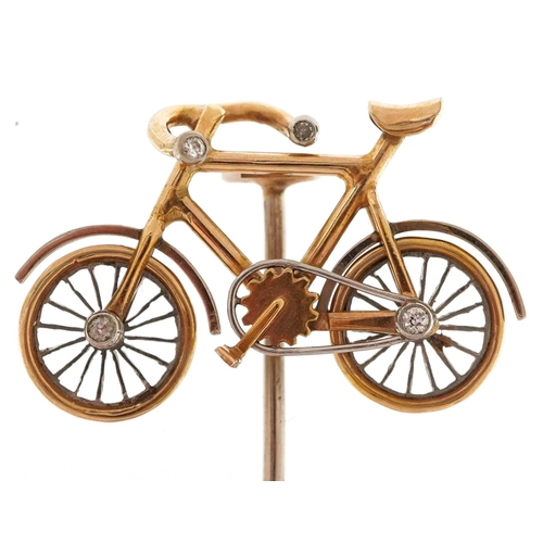 2068 - An antique unmarked gold and platinum stickpin in the form of a bicycle set with diamonds, having ro... 