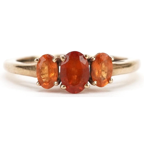 2348 - A 9ct gold orange garnet three stone ring, size N, 1.9g.