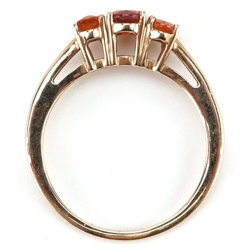 2348 - A 9ct gold orange garnet three stone ring, size N, 1.9g.