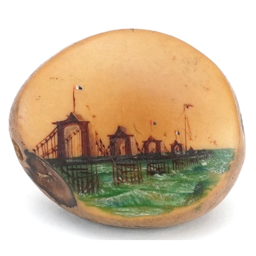 128 - A late 19th/early 20th century nut hand painted with The Chain Pier Brighton, 5cm in length.