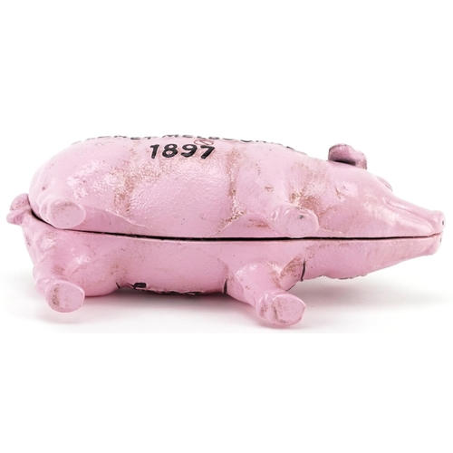 1303 - A cast iron model of a pink piggy bank, 19.5cm in length.