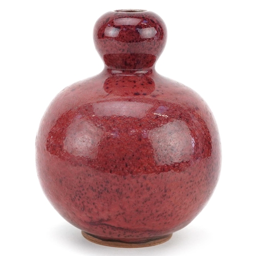 1323 - A Chinese sang de boeuf style pottery vase, 16cm high.