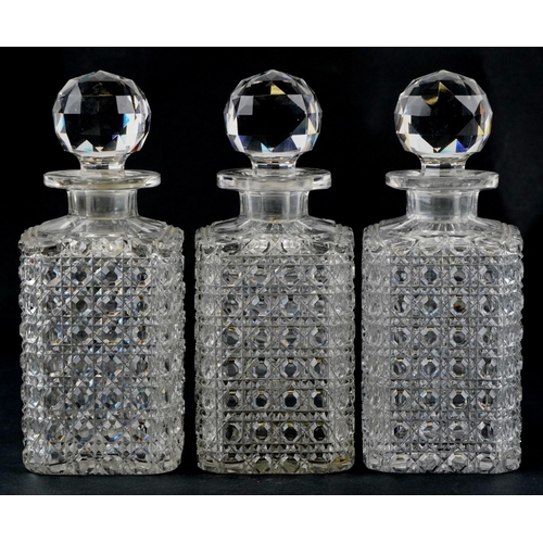 1273 - A set of three early 20th century cut glass decanters and stoppers, 24cm high.