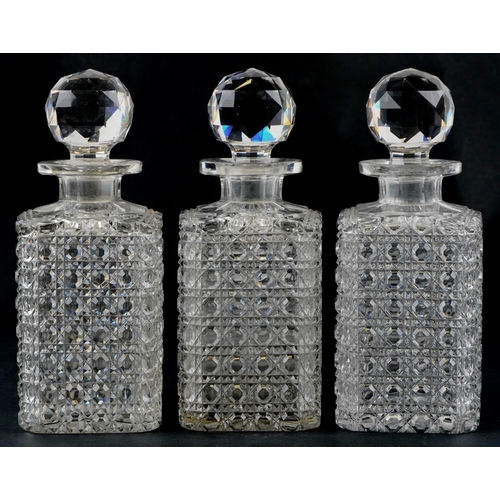 1273 - A set of three early 20th century cut glass decanters and stoppers, 24cm high.