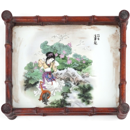 343 - A Chinese hardwood tray inset with a Chinese porcelain panel hand painted with a girl amongst flower... 