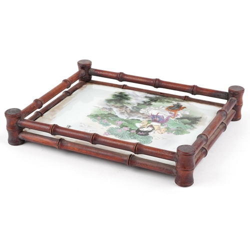 343 - A Chinese hardwood tray inset with a Chinese porcelain panel hand painted with a girl amongst flower... 