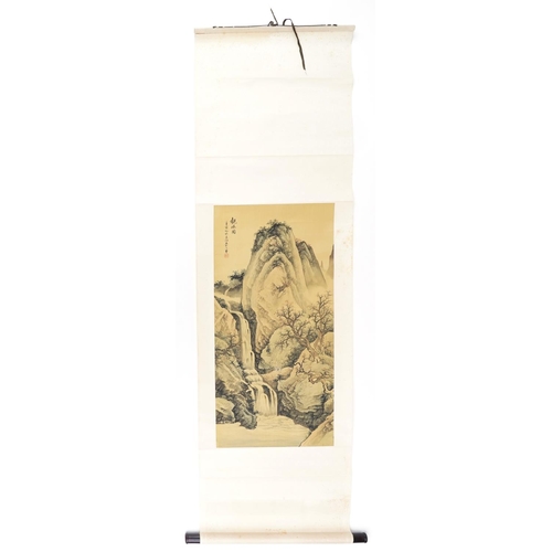 308 - A Chinese wall hanging scroll decorated with figures beside a waterfall and mountains with blossomin... 