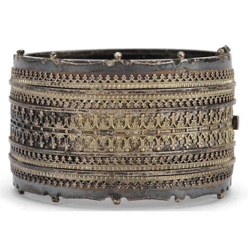 618 - A large Victorian unmarked silver hinged bangle, 6cm wide x 3.5cm high, 55.0g.