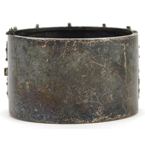 618 - A large Victorian unmarked silver hinged bangle, 6cm wide x 3.5cm high, 55.0g.