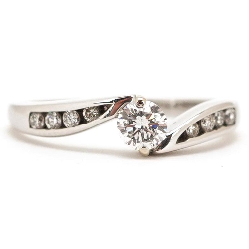 445 - An 18ct white gold diamond solitaire crossover ring with diamond set shoulders, total diamond weight... 