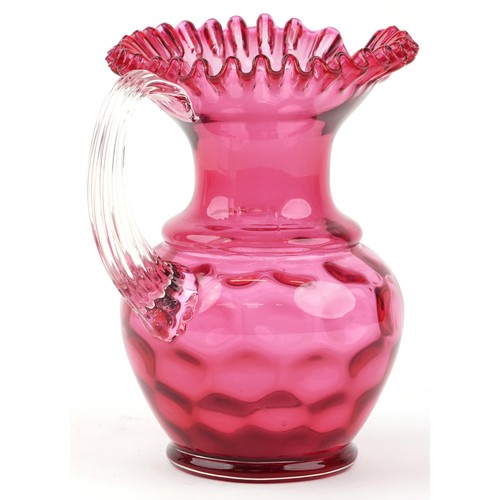 66 - A Victorian cranberry glass jug with frilly edge and clear glass handle, H-25cm