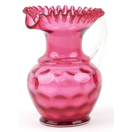 66 - A Victorian cranberry glass jug with frilly edge and clear glass handle, H-25cm