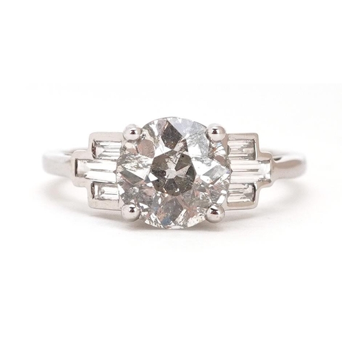 296 - An 18ct white gold old cut solitaire diamond ring with baguette cut diamond set shoulders, the solit... 