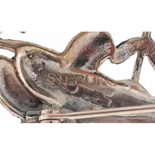 375 - A Modernist sterling silver brooch in the form of dolphins, 3.2cm wide, 9.6g.