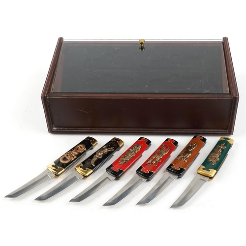 1249 - A group of six Franklin Mint Collector knives, various designs, within a display case, 34cm wide.