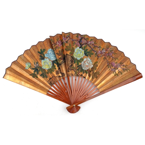 1379 - A large Chinese hand painted folding fan, mid 20th century, decorated with flowers, 61cm in length.