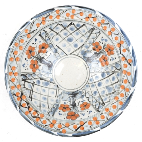 122 - A late 20th century studio pottery bowl with floral decoration, marks to the base, 23cm in diameter.