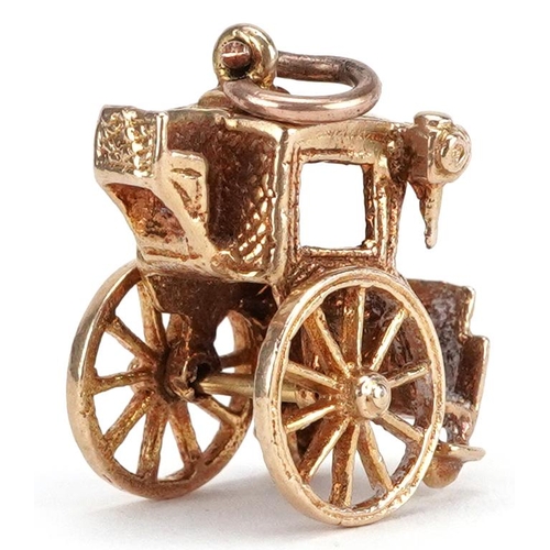 77 - A 9ct gold charm in the form of a horse and carriage, 1.7cm high, 4.9g.