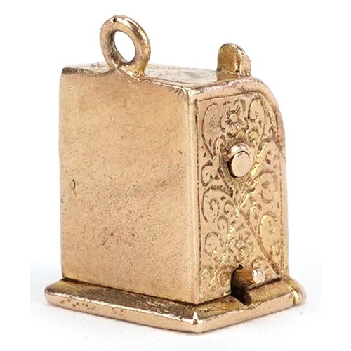 124 - A 9ct gold charm in the form of a one armed bandit slot machine, 1.4cm high, 7.0g.