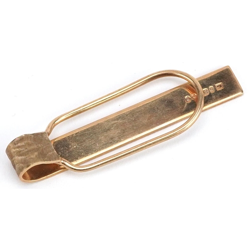 42 - A 9ct gold engine turned tie clip, 5cm in length, 6.5g.